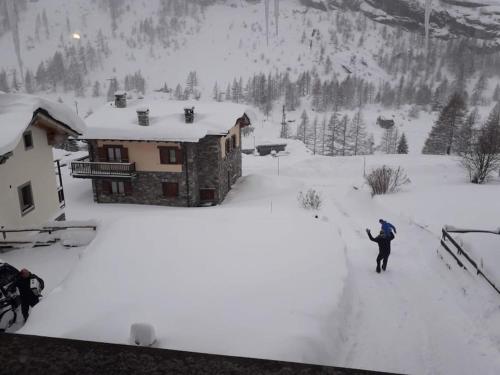 a person standing in the snow in front of a house at Chalet a due passi piste da sci in Valgrisenche