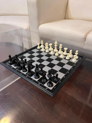 a chessboard on a glass table in a living room at Ananya Comfortss in Hospet