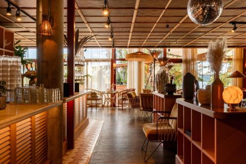 a restaurant with a bar with tables and chairs at Ellery Beach House in Lidingö