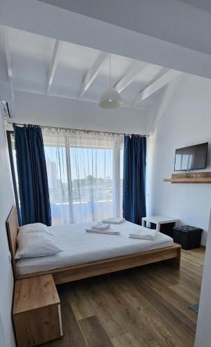 una cama grande en una habitación con una ventana grande en Vila Ayra, en Eforie Nord