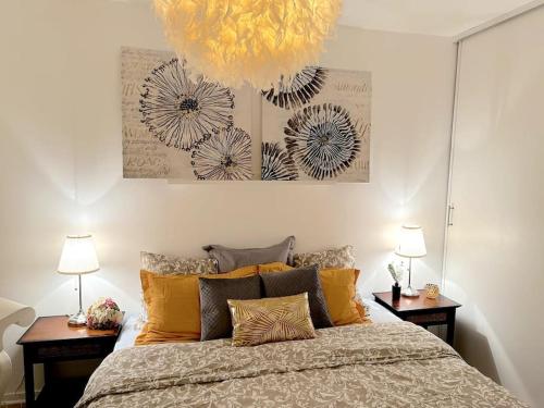 - une chambre avec un grand lit, deux tables et un lustre dans l'établissement Bon apart 5 min from Disneyland & village Paris, à Montévrain