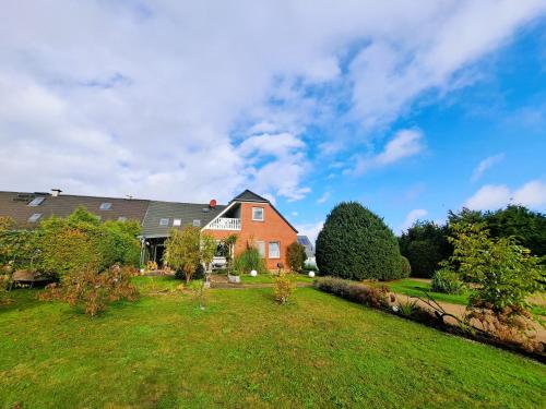 a house with a grassy yard and a house at Ferienwohnung "Weit Blick" Objekt-ID 15678-6 in Neu Schloen