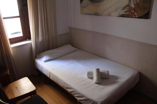 a small bed in a room with a cross on it at Aires de gredos/bajo in Candeleda