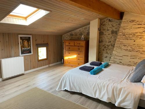 a bedroom with a bed and a skylight at Gites de Verger, stylish self catering cottages in Sos in Sos
