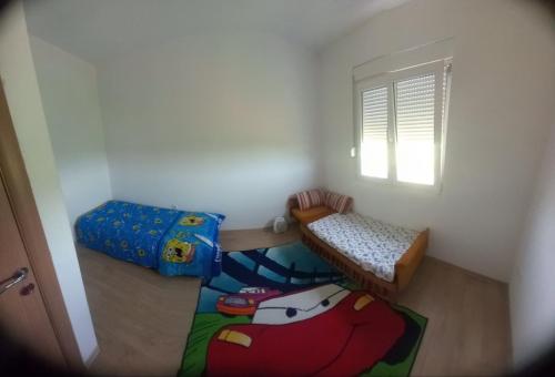 a small room with two beds and a window at Imanje Boljevic in Dubrava