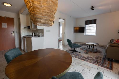 a living room with a wooden table and chairs at Hotel Tesselhof in De Koog
