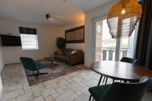 a living room with a table and chairs and a couch at Hotel Tesselhof in De Koog
