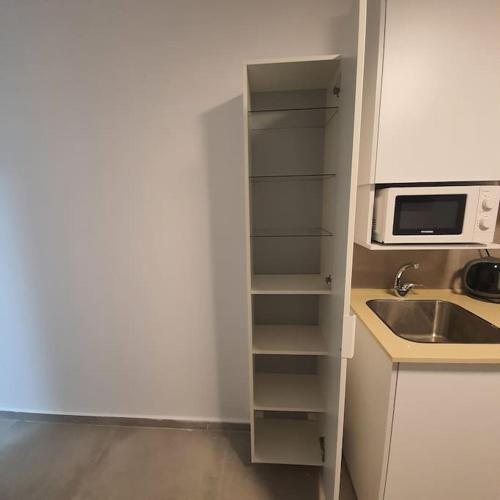 a kitchen with a sink and a microwave at Ryo 12 דירת סטודיו ליד חוף הים לנופש מושלם in Bat Yam