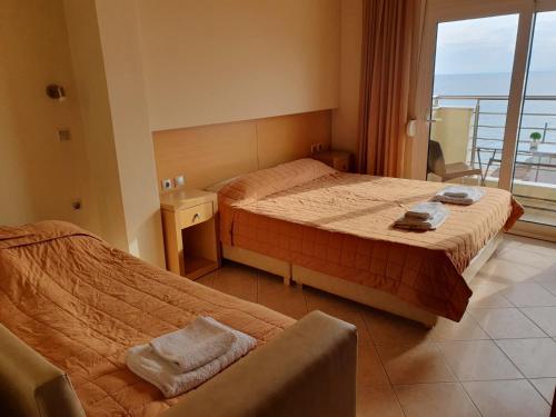 a hotel room with two beds and a balcony at SeaView Studios in Potos