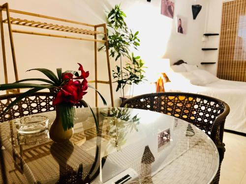 a glass table with a vase with red flowers on it at Janice Villa Arambol in Arambol