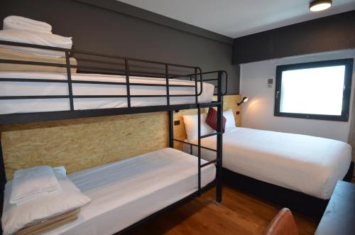 a room with two bunk beds and a window at ibis budget Sydney East in Sydney