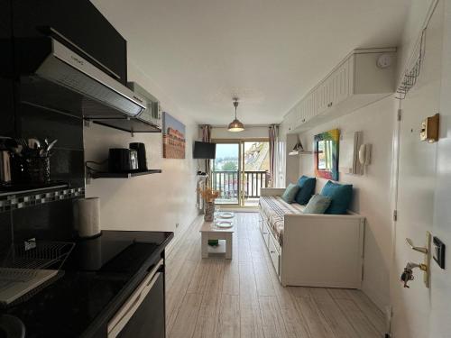 une cuisine et un salon avec un canapé dans l'établissement Studio Le Trouvillais proche du centre et de la gare, à Trouville-sur-Mer