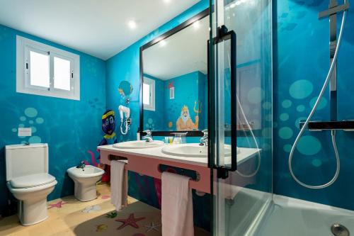 a blue bathroom with a sink and a toilet at Hotel Magic Fantasy in Oropesa del Mar
