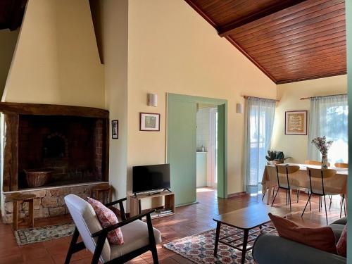 a living room with a fireplace and a table at Casa Chã in Alcobertas