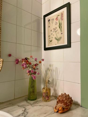 two vases with flowers on a counter in a bathroom at Casa Chã in Alcobertas