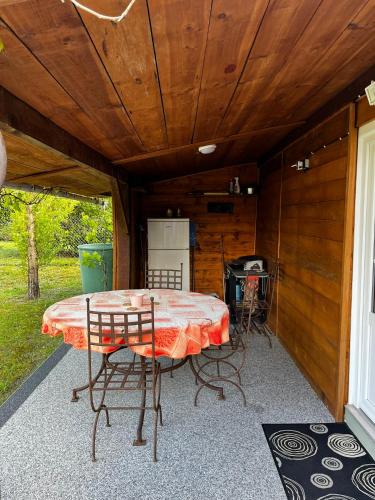 a patio with a table and chairs in a cabin at Gite de Haute Saintonge à Crazannes in Crazannes