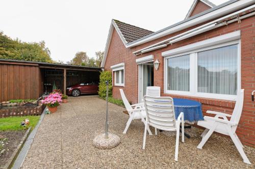 a patio with a table and chairs and a house at Haus Gartenidylle in Wesselburen