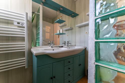 une salle de bain avec un lavabo et un miroir dans l'établissement Le Martinet - Maison avec piscine et jaccuzi, à Le Martinet