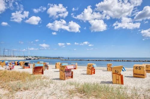 a group of chairs on a beach near the water at Hafenperle in Schilksee