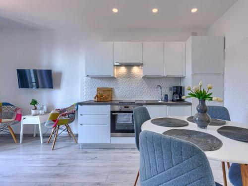 a kitchen with white cabinets and a table and chairs at Apartment Boris by Interhome in Raša
