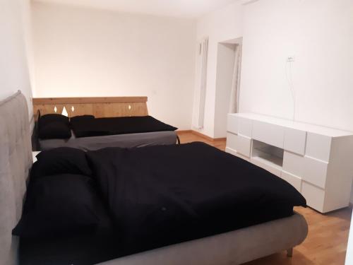 a bedroom with two beds and a bed frame and a window at Luxury House Bergamo vicino aeroporto Orio e Ospedale Papa Giovanni XXIII in Curno