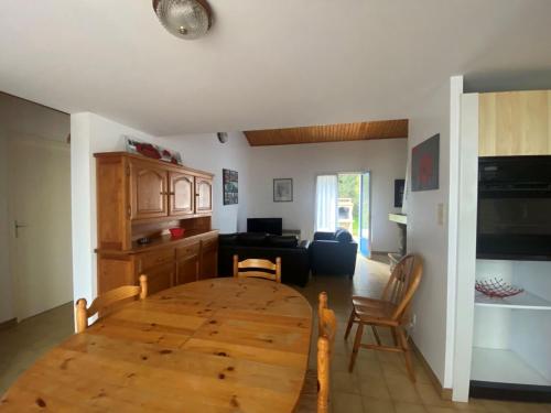 Il dispose d'une cuisine et d'un salon avec une table et des chaises en bois. dans l'établissement Holiday Home Les Tourteaux by Interhome, à La Tranche-sur-Mer