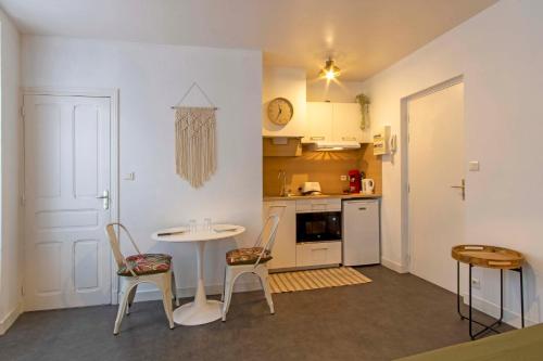 une petite cuisine avec une table et des chaises dans une pièce dans l'établissement Les palmiers de Brive, à Brive-la-Gaillarde