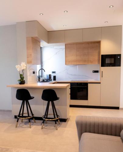 a kitchen with two bar stools and a counter at Villa Barovic - Delux Apartment in Mlini
