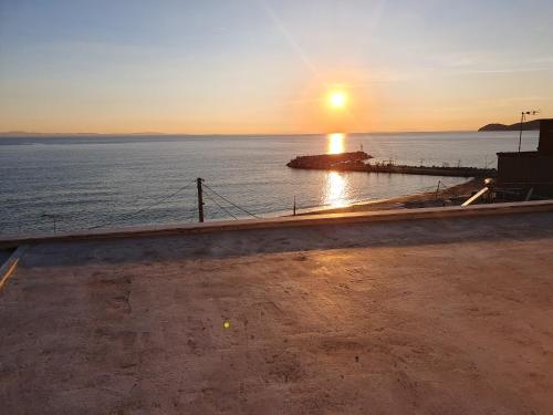 a sunset over a body of water with a pier at SeaView Studios in Potos