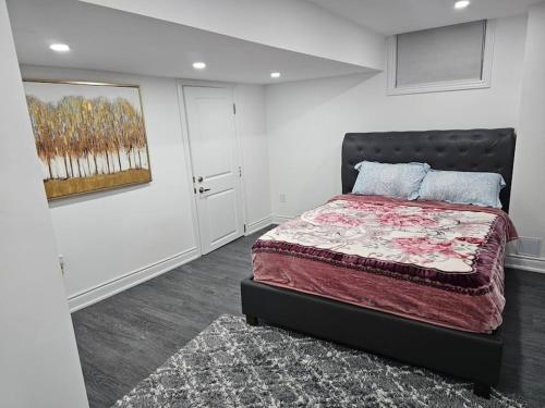 una camera da letto con un letto e un quadro sul muro di Cosy Spacious 2 bedrooms a Oakville