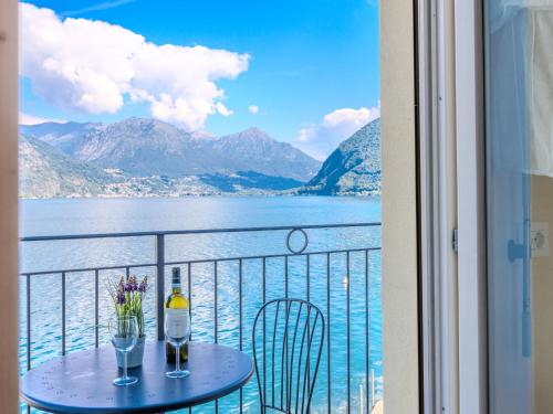 a balcony with a table with a bottle and two glasses at Apartment Sole by Interhome in Claino