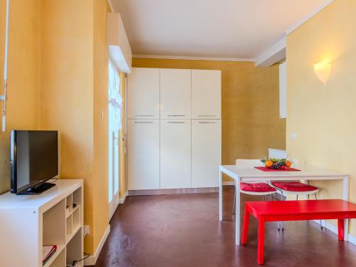 a living room with a white table and a red stool at Apartment Sole by Interhome in Claino