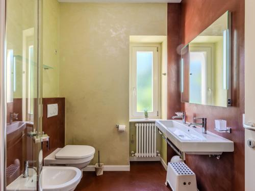 a bathroom with a sink and a toilet and a mirror at Apartment Bosco by Interhome in Claino