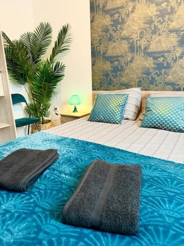 - une chambre avec 2 lits avec des draps bleus et une plante dans l'établissement Confortable T4 Équipé à Roubaix - 200m Métro, à Roubaix