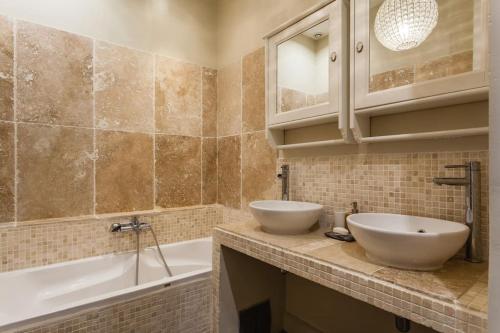 La salle de bains est pourvue de 2 lavabos blancs, d'une baignoire et d'une chambre. dans l'établissement Loft coeur Panier, à Marseille
