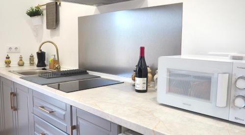 a kitchen with a microwave and a bottle of wine at Apartamentos Muralla Sacra in Sober