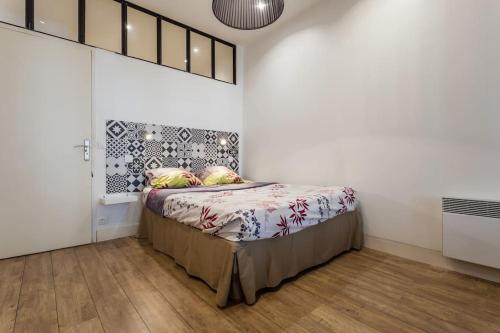 une chambre avec un lit dans une pièce blanche dans l'établissement Loft coeur Panier, à Marseille