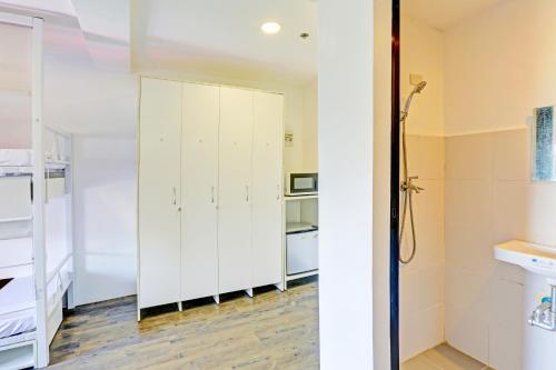 a bathroom with white cabinets and a mirror at Spot On Hostel ,Taguig Manila Formerly MYTOWN HongKong in Manila