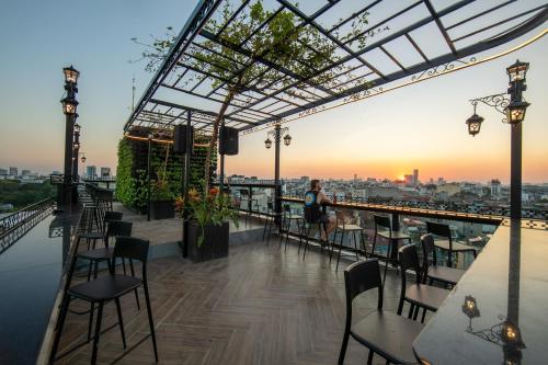 a rooftop bar with chairs and tables and a view of the city at Lakeview Backpackers Hostel & Rooftop Bar in Hanoi