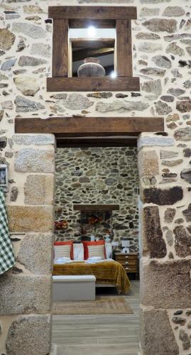a bedroom with a stone wall with a bed in it at Apartamentos Muralla Sacra in Sober