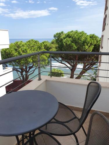 a table and chairs on a balcony with the ocean at Hotel Cala Luna in Cala Gonone
