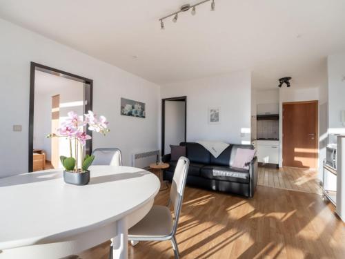 a living room with a white table and a couch at Apartment Appartement 64-202 by Interhome in Bredene
