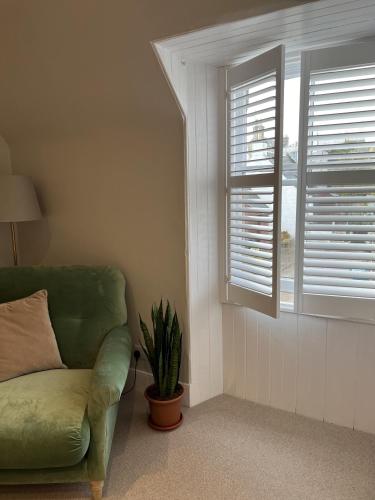 a living room with a green couch and a window at No. Ten Guesthouse in Tain