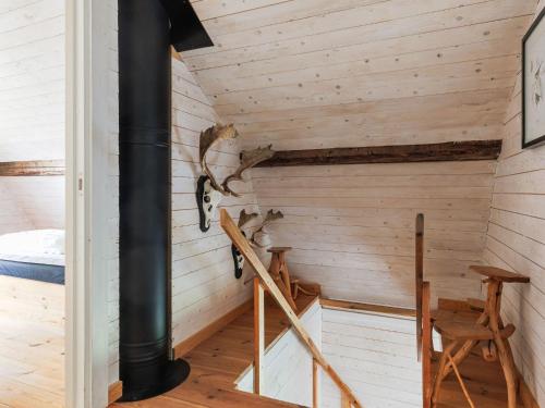 a room with wood paneling and a spiral staircase at Chalet Grönede by Interhome in Kisa