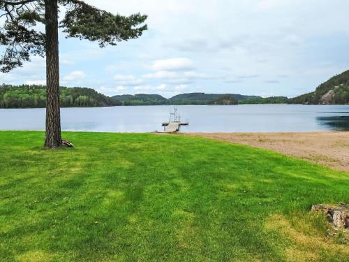 a picnic table on the shore of a lake at Chalet Grönede by Interhome in Kisa