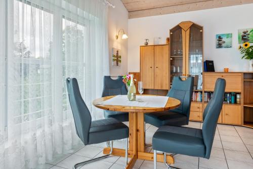 a dining room with a wooden table and blue chairs at Ferienwohnungen Böhme in Konstanz