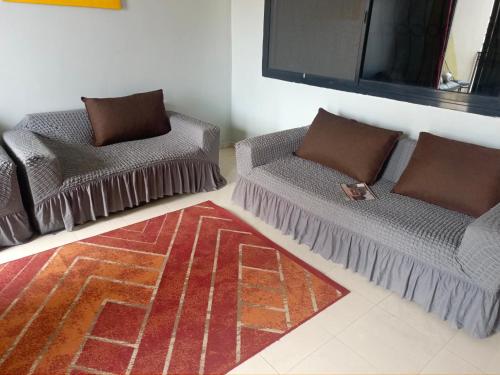 a living room with two couches and a flat screen tv at Mermoz Dakar in Dakar