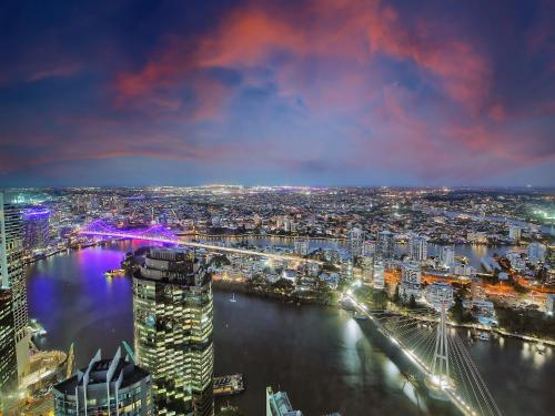 a city at night with a river and a bridge at The Gatsby Escape Skytower Luxury Living at Level 71 in Brisbane