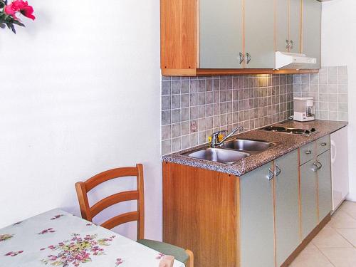 małą kuchnię ze zlewem i stołem w obiekcie Apartment Zdenko-1 by Interhome w mieście Kali