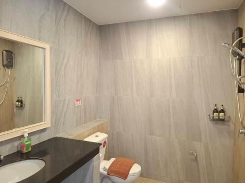 a bathroom with a sink and a toilet and a mirror at Karon Living Room - SHA Plus in Karon Beach